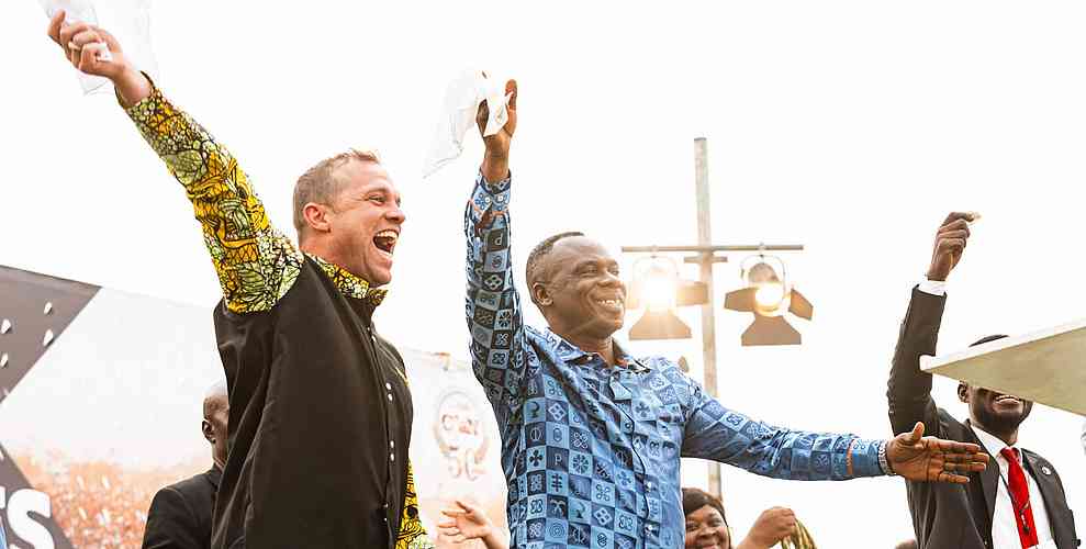 The Governor dances joyfully on stage with Evangelist Joe Turnbull