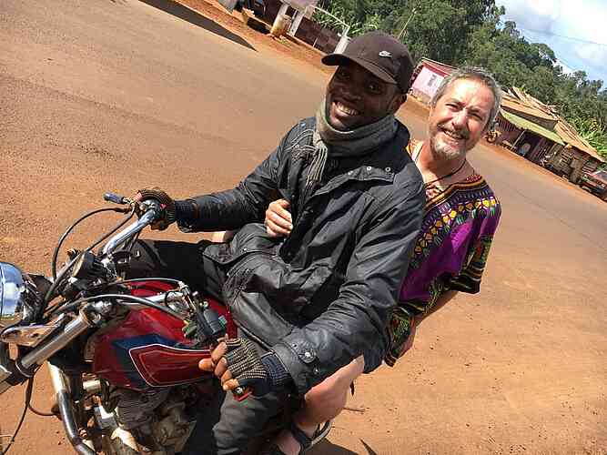Greg takes a ride into town on a motorbike taxi
